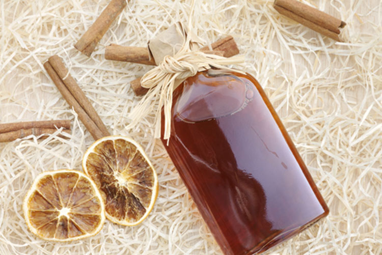  A bottle of rum with cinnamon sticks and lemon next to it