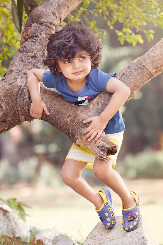 A boy trying to climb up a tree.