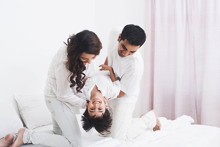 Mom and dad playing with their adorable son.