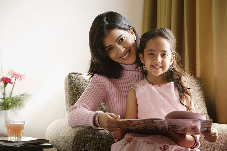 A mother reading a book with her daughter.