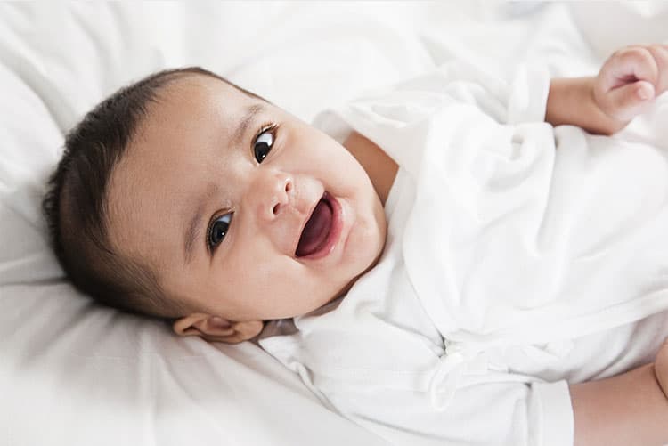 A cheerful baby wearing a romper.