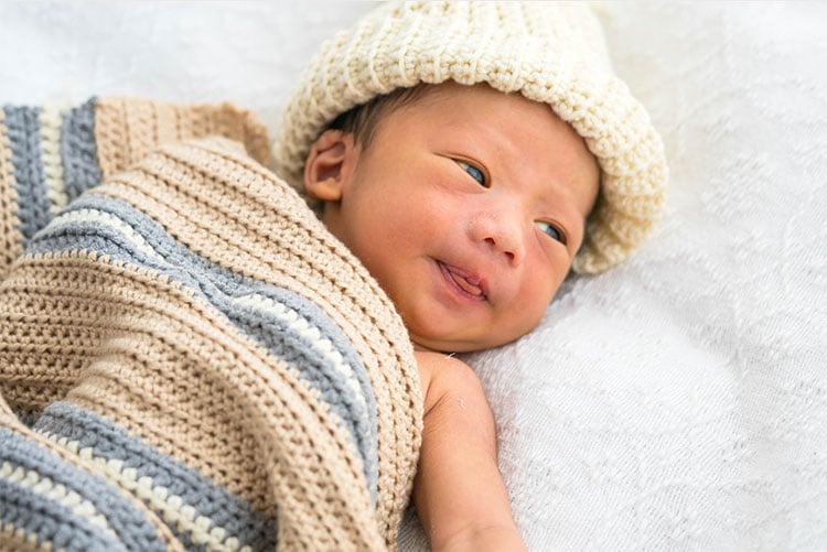 A newborn wearing a beanie.