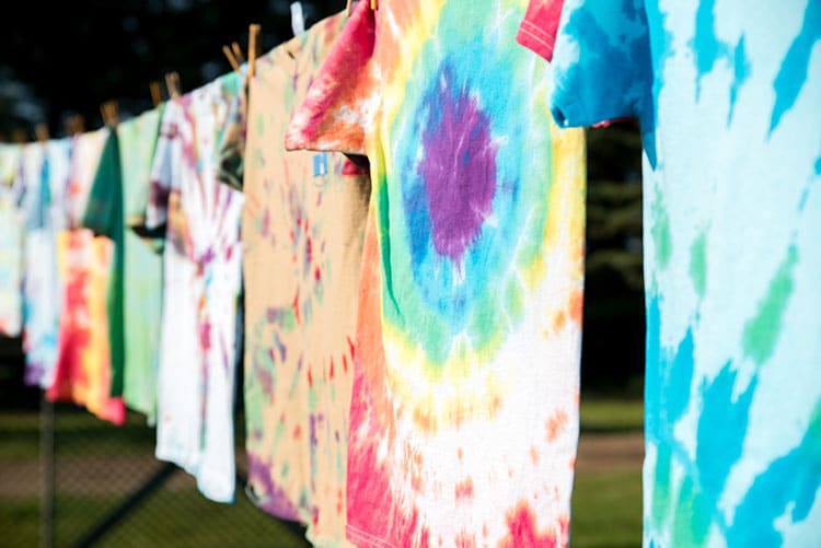 Tie-and-dye t-shirts hung after dyeing.
