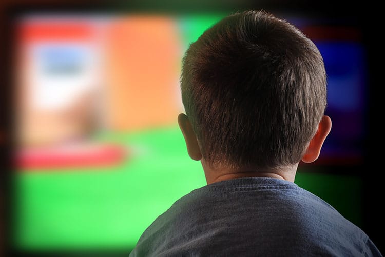 A young boy watching TV.