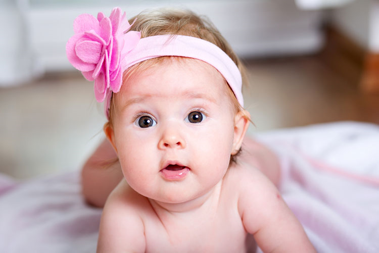 Adorable infant wearing a pink headgear!
