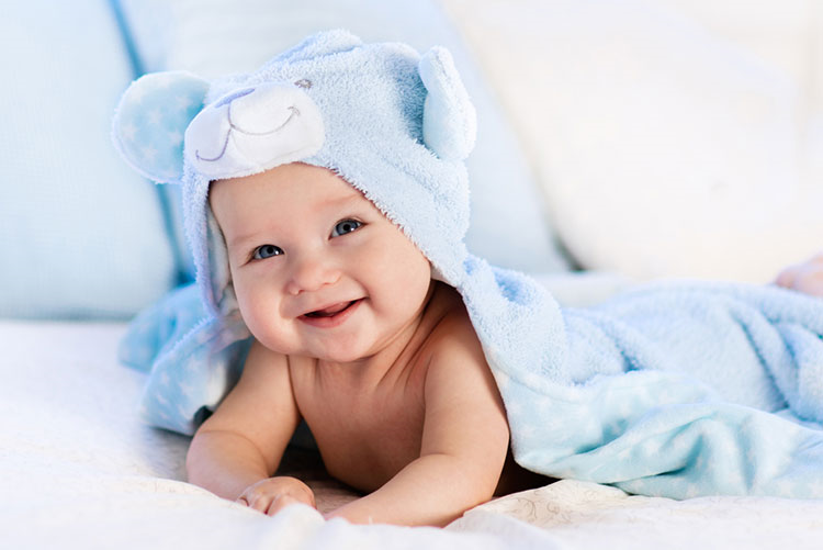 Smiling infant wrapped in a blue towel!