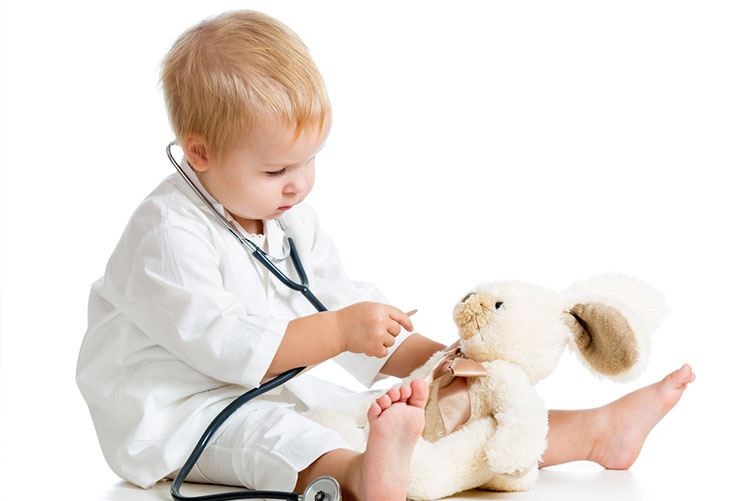 Young boy playing doctor, examining his plushie with a makeshift stethoscope!