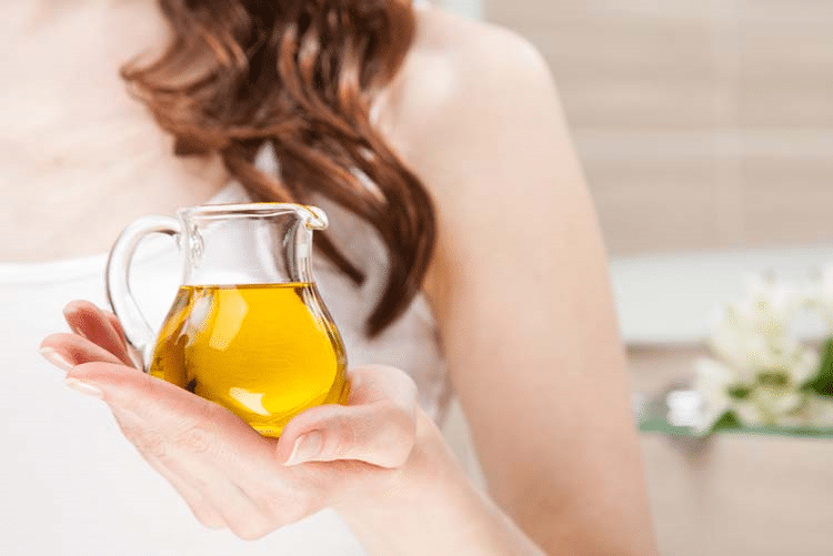 Woman holding a glass jar filled with olive oil!