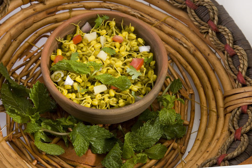 Sprout chaat in a bowl with mint leaves on the side