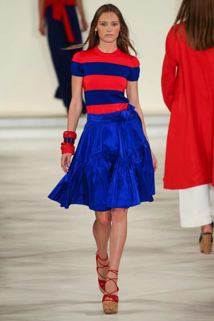 Model walks the ramp wearing a Cobalt Blue skirt and multi-coloured top paired with red and beige wedges!