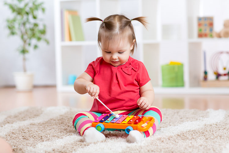 Adorable young toddler playing a musical instrument!