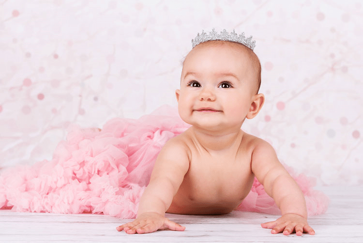 Cute infant in pink ruffle dress wearing a makeshift crown!