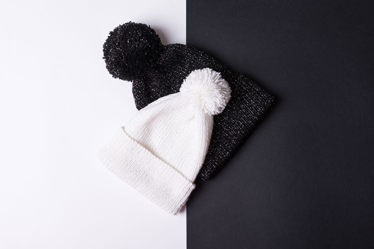 Black and white beanies with pom pom on top