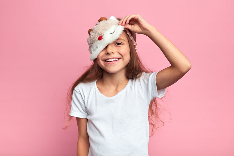 Girl lifting her eye mask and peeking from it