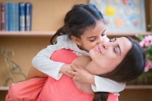 Daughter kissing mother