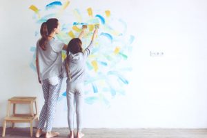 Mom and daughter painting on the wall