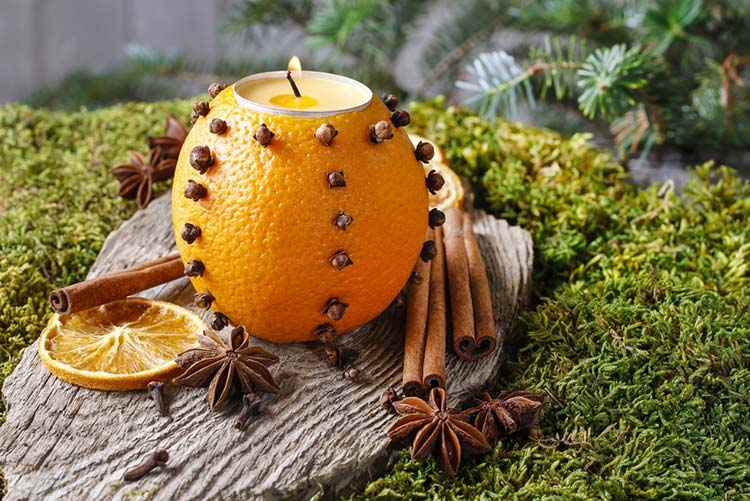 Cloves stuck to orange peel with a candle in the middle