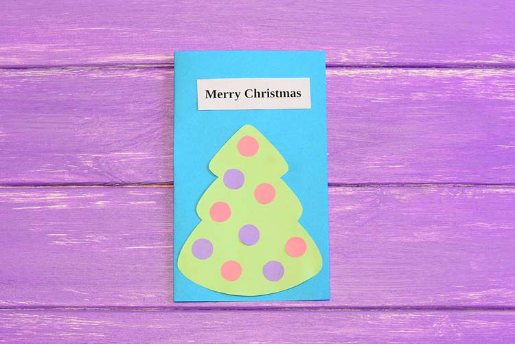 Blue Christmas greeting card on a purple table 