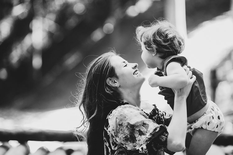 Mother lifting child smiling