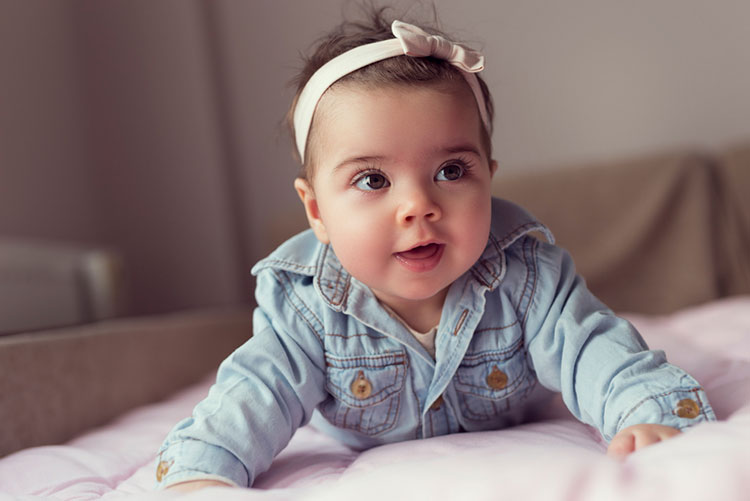 Baby lying down on the bed and smiling