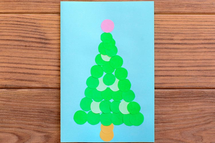 Green Christmas card against a brown wood table