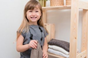 Girl holding a tee shirt and smiling