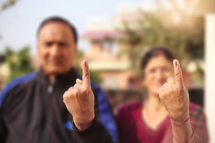 A man and woman showing their inked fingers after an election.