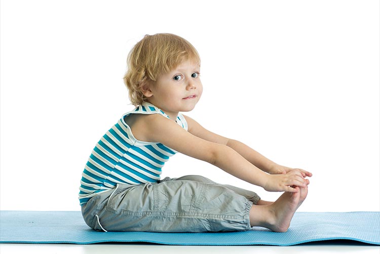A young boy doing yoga.