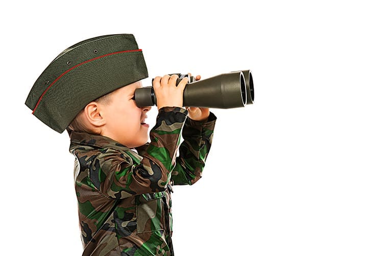 A baby boy looking through his binoculars.