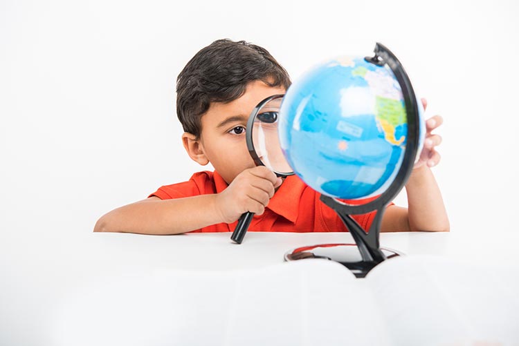 A young boy looking keenly on his globe.