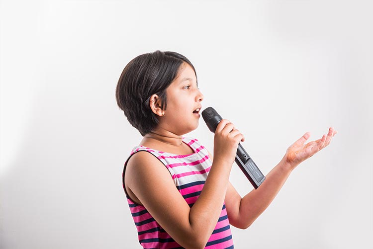 A girl singing a song on a mic.