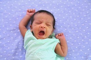A newborn girl yawning.
