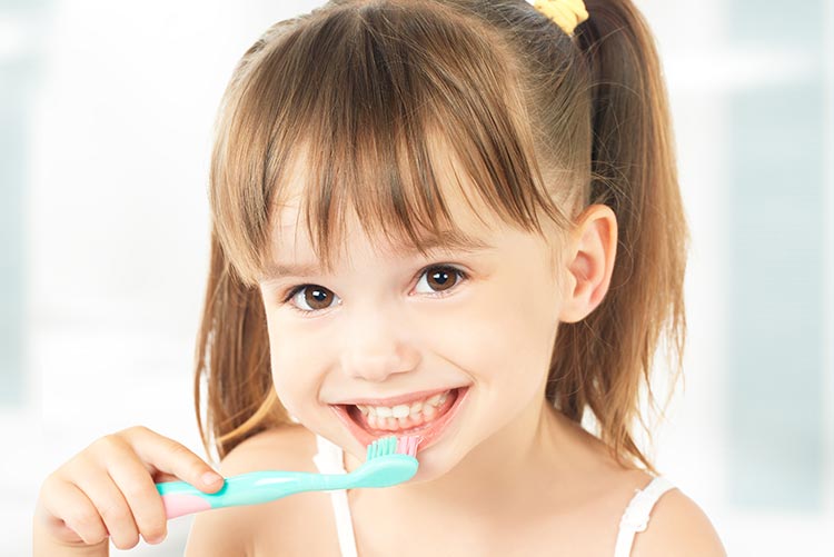 A little girl excited about brushing her teeth.