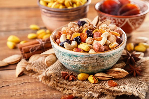 A bowl of dry fruits placed on a table.