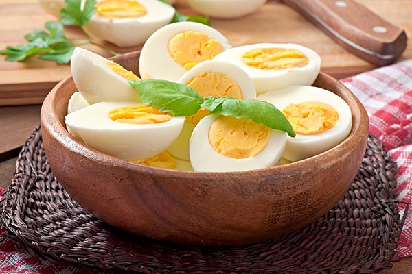 Boiled eggs placed in a wooden bowl.