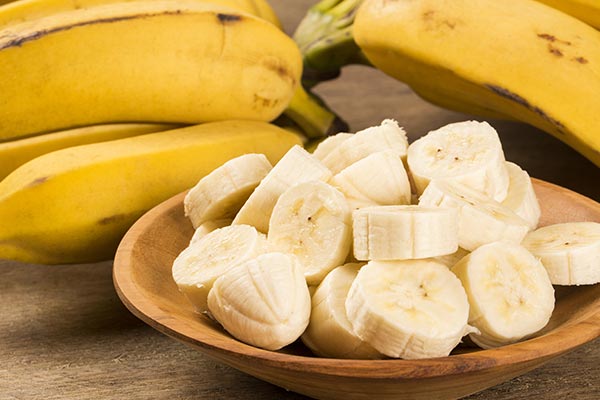 Bananas chopped and placed in a wooden plate.