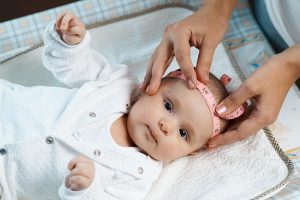 A baby's head circumference being measured.