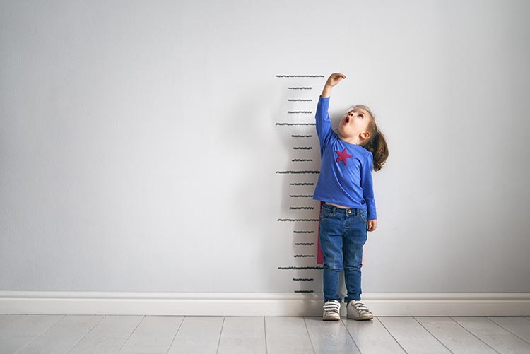 A little girl measuring her height.