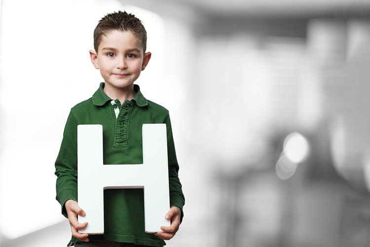 Little boy holding the letter ‘H’