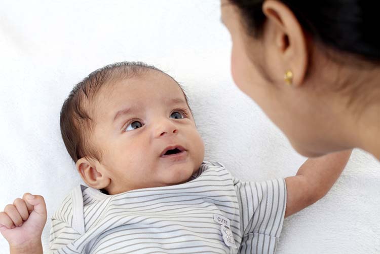 Mother playing with her newborn infant.