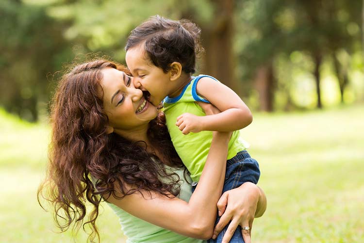 happy mother and son - son giving his mom a kiss on the cheek!