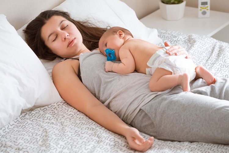 Mother and her newborn taking a nap.