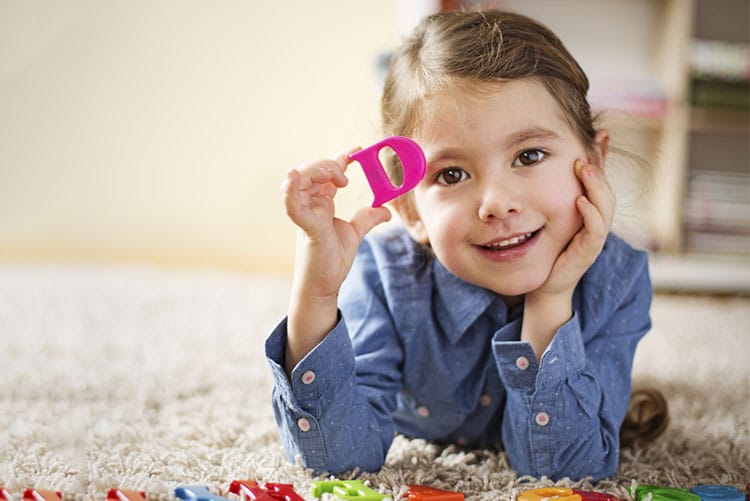 Little girl holding the letter ‘D’