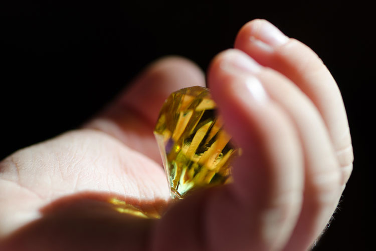 Baby holding a yellow diamond in its hand
