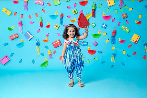 A girl wearing an ethnic dungaree smiling.