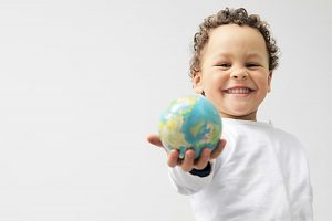 A boy learning holding on to a globe learning world geography.