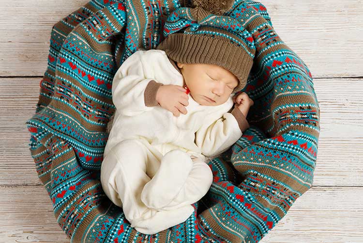 A newborn wearing a woolen footie.