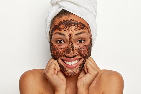 A young lady doing a face scrub.