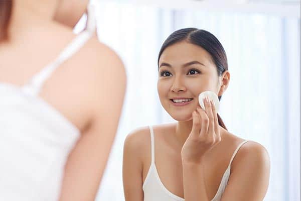 A girl applying a toner after the Face Clean Up.