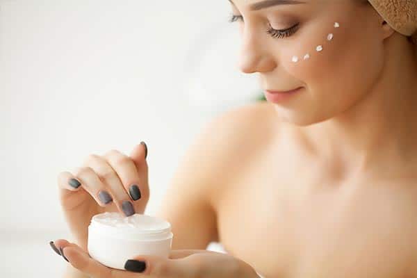 A lady moisturising her face.